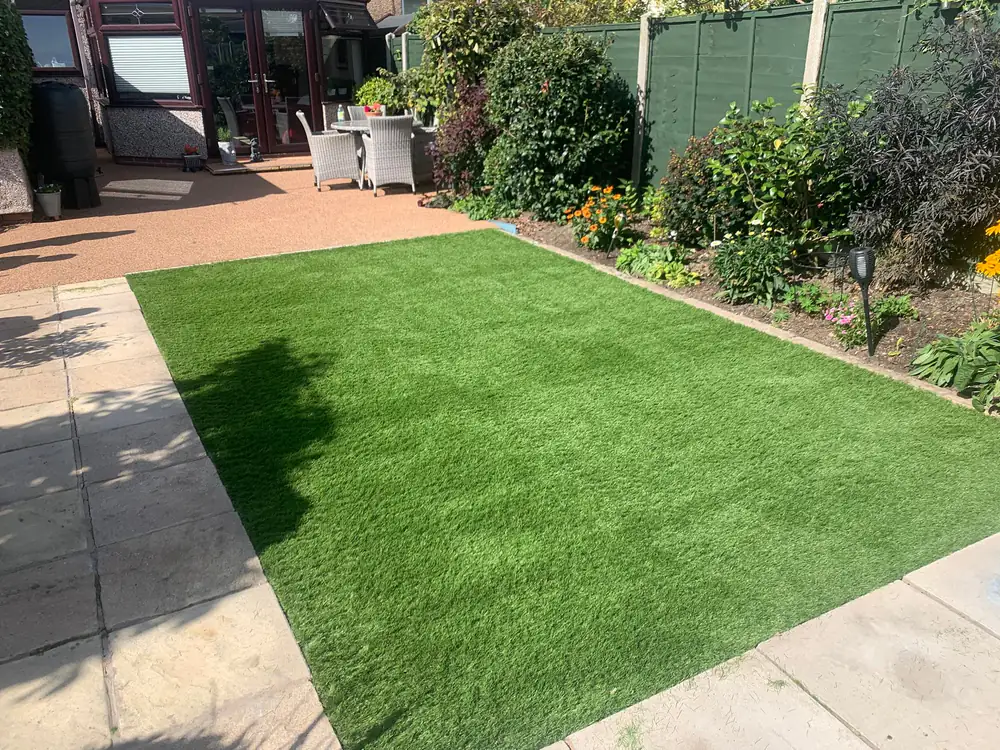 Beautifully installed artificial grass in a backyard garden setting