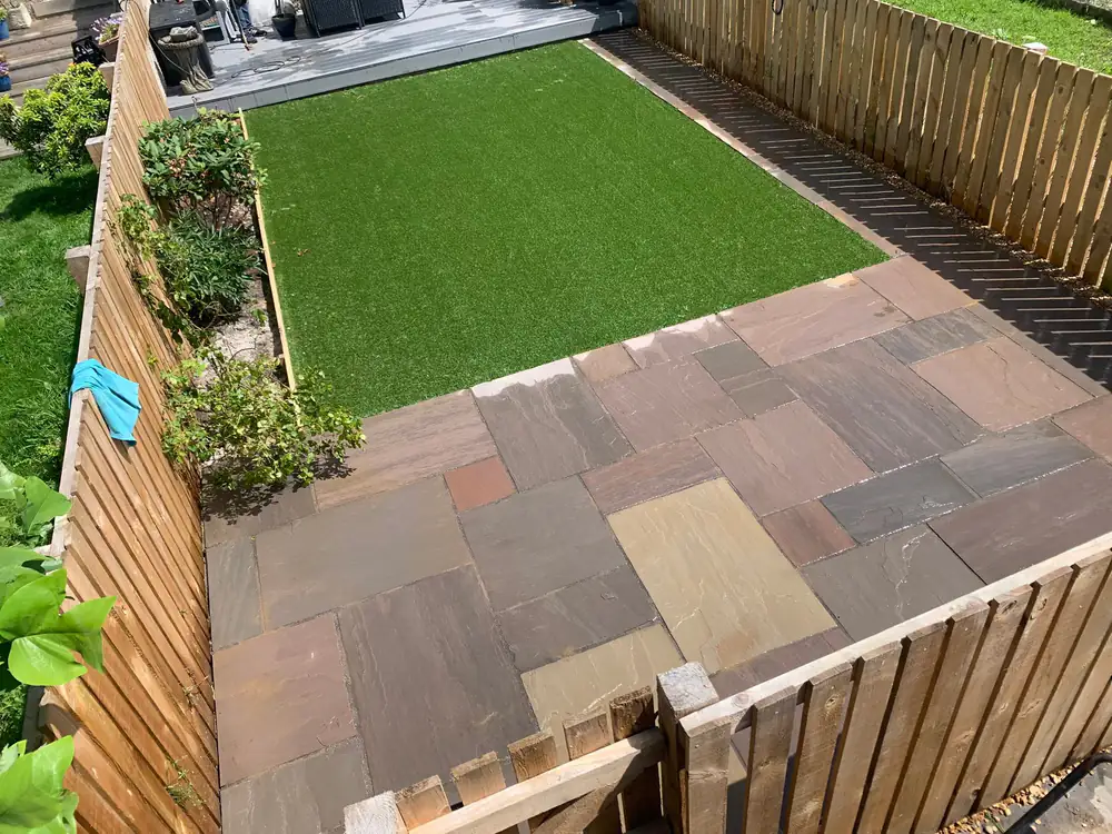 Garden patio with artificial grass and wood fence