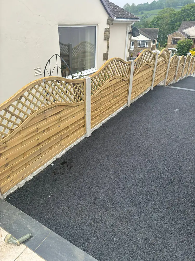 Scalloped picket fence with wooden lattice and concrete posts